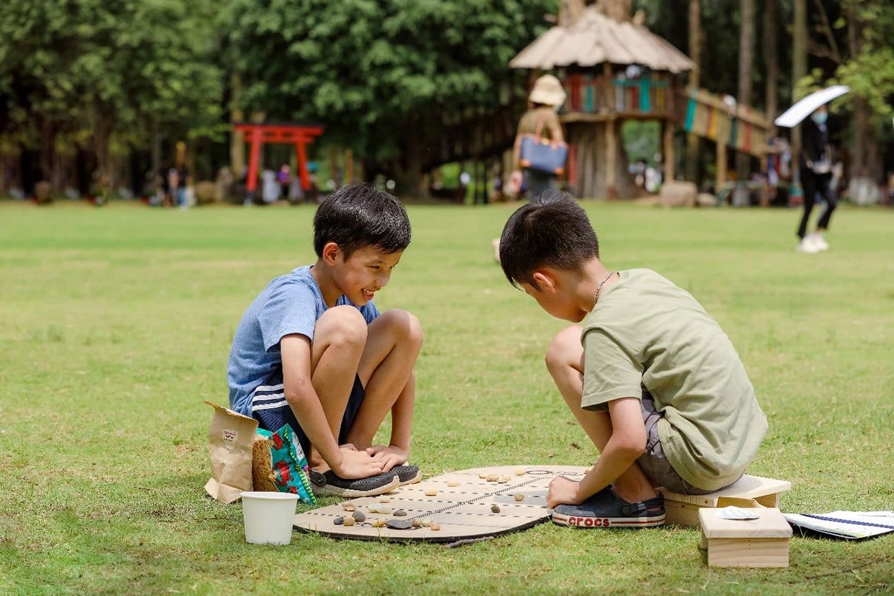 Trẻ em chơi trò chơi dân gian giữa thiên nhiên thoáng mát.